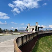 a wooden walkway with a building in the background