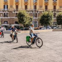 a group of people riding bikes down a street