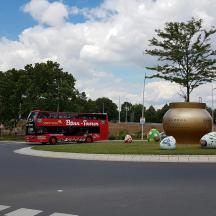 bas dua tingkat merah memandu di jalan raya dengan bola