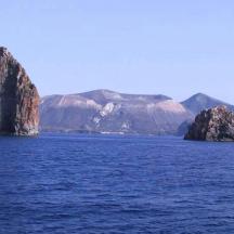 eine Insel im Wasser mit Bergen im Hintergrund