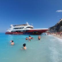 a group of people in the water in front of a cruise ship