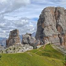 a large rocky mountain with a trail in front of it