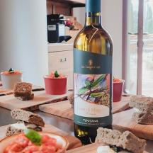 a bottle of wine sitting on a table with food