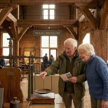 an older man and woman looking at an exhibit in a museum
