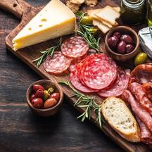 a table topped with cheese and meats and bread