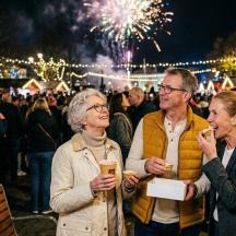 a group of people standing in a crowd watching fireworks