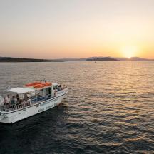 a ferry boat in the water at sunset