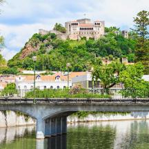eine Brücke über einen Fluss mit einer Burg auf einem Hügel