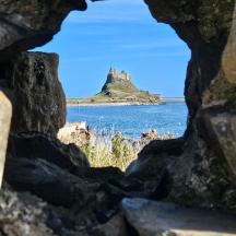 a view from a rock cave of a island in the water