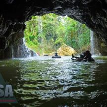 a group of people in a cave in the water