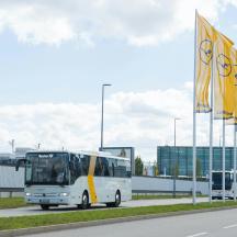a white bus driving down a road next to a building