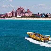 a yellow boat in the water in front of a beach