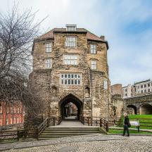 an old stone building with a person standing in front of it