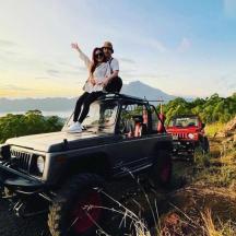 a man and a woman sitting on top of a jeep