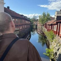 Eine Frau blickt über einen Fluss in einer Stadt