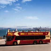 a red double decker bus driving down a street