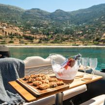 a table on a boat with a tray of food and wine glasses