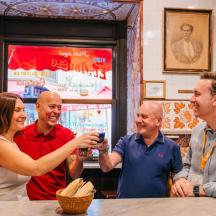 a group of people standing around a table in a restaurant