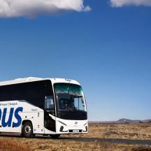 a bus driving on a road in the desert