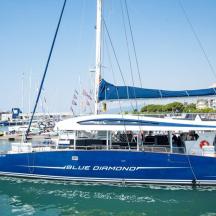 a blue displacement sailboat docked in a harbor
