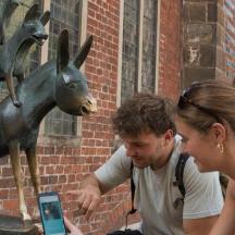 a man and a woman looking at a fake deer statue
