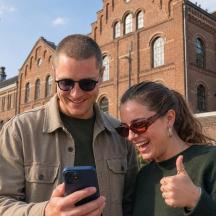 мушкарац и жена гледају у мобилни телефон