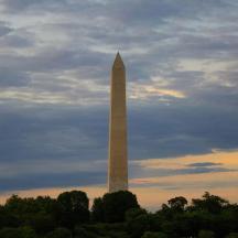 a washington monument with a cloudy sky in the background