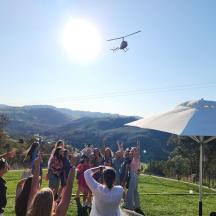 a group of people standing in a field with a helicopter