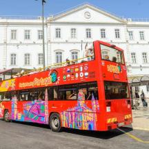 Ein roter Doppeldeckerbus parkt an einer Bushaltestelle.