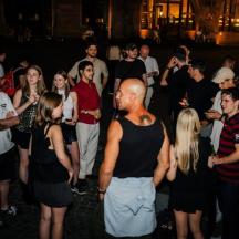 un gruppo di persone in piedi in mezzo alla folla a una festa