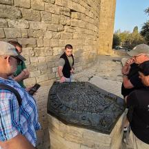 a group of people standing next to a stone wall