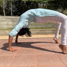 a woman doing a yoga pose on a tiled floor