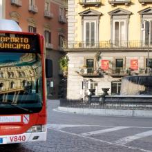 一辆红色巴士正沿着城市街道行驶