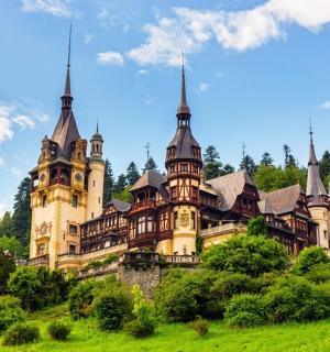 un antic castell en un turó verd amb arbres