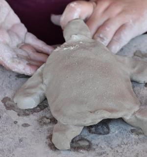 a person making a stuffed teddy bear on a table