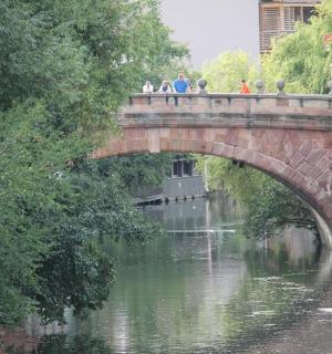 a group of people standing on a bridge over a river