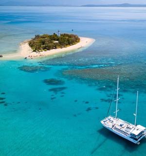 a boat in the water next to a small island
