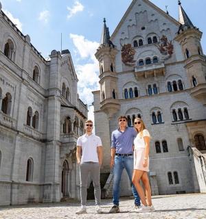 three people standing in front of a castle