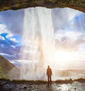 一名男子站在瀑布前