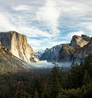 a view of a valley with trees and mountains