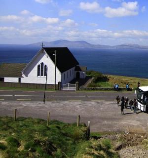 a horse drawn bus parked in front of a church