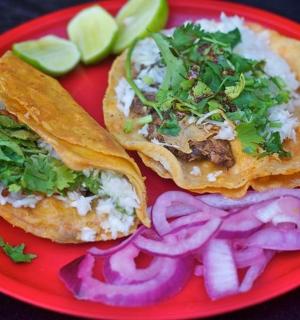 一个红色盘子,上面放着两个三明治和洋葱