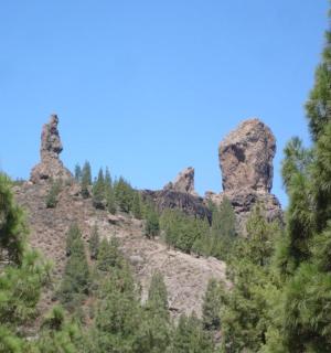 ein Berg mit Felsen und Bäumen und einem blauen Himmel