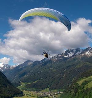 一个人带着降落伞飞越一座山