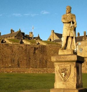 一座站在城堡前的男人雕像