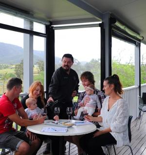 un groupe de personnes assises autour d'une table sur un porche