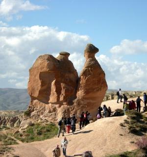 a group of people standing next to two rock formations