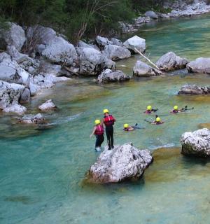 skupina lidí v řece s kameny