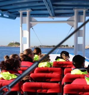 sekumpulan orang yang duduk di atas bot di atas air