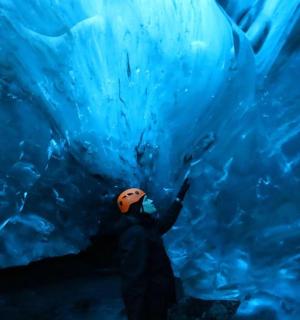 站在冰洞前的人